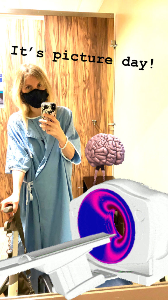 Ardra is wearing a Covid mask, a hospital gown and ID bracelet. She is standing in the MRI change room. She has added graphics of an MRI machine and brain with legs to the image.