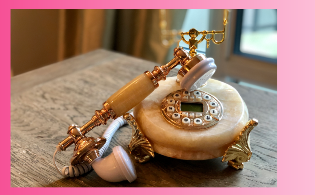An antique style phone made of peach marble with gold details. It's so pretty you'd think it would make hearing about new lesions on your MRI easier to accept.