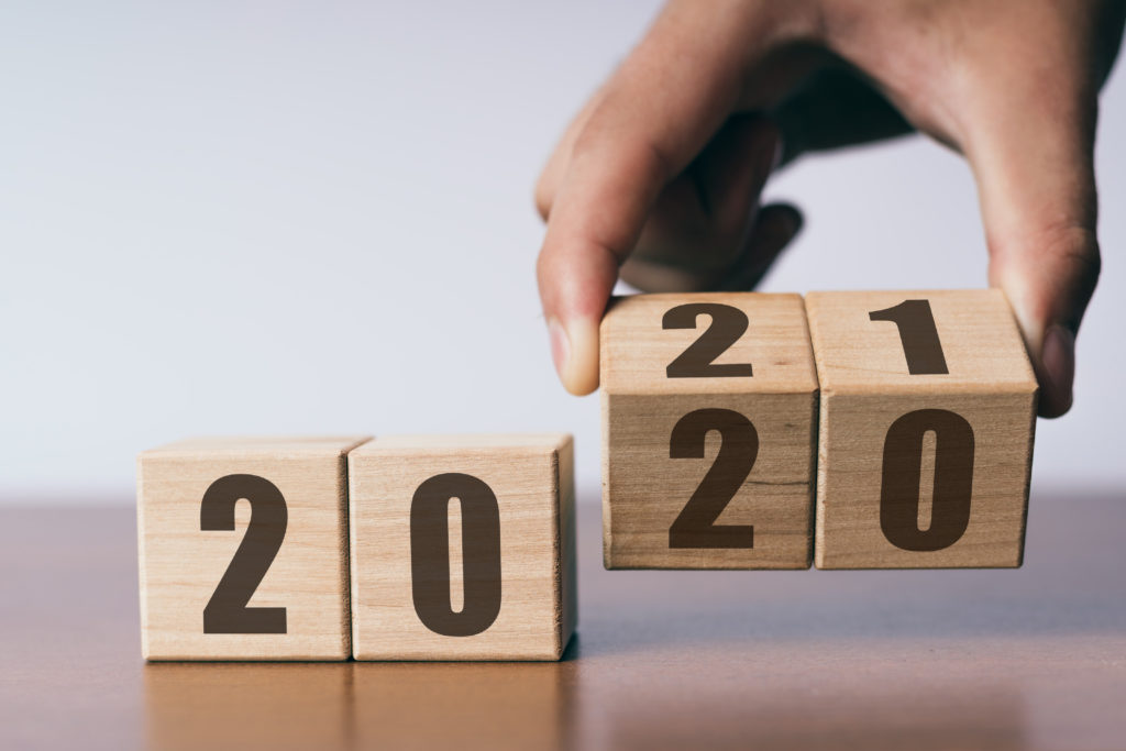 A calendar of wooden blocks marks the transition from 2020 to 2021 as we feel the pressure to have a happy new year, the blocks underscore that nothing much has changed